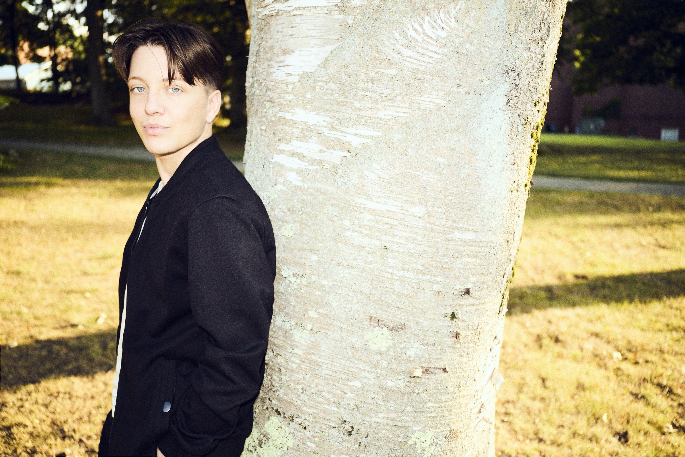 K. Iver leaning against a birch tree in late light